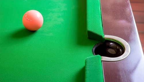 AI generated image showing a billiards table closeup with ball and pocket