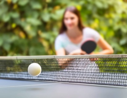 AI generated table tennis scenery including a ball, table with netting and female player