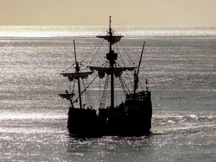 Silhouette of a historic sailing ship near Madeira in glittering water ambiance