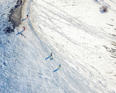 Aerial view, pedestrians, sledges and skis in the snow at the Mottbruchhalde, Brauck, Gladbeck,