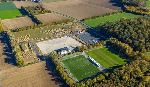 Aerial view, construction site and new sports field with stands and a club building with sports day