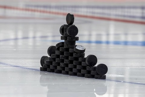 Ice hockey symbol image: Close-up of pucks stacked on the ice for the warm-up game