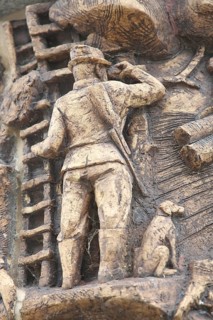 Relief on the market fountain, sculpture, hunter with shotgun watching with binoculars, hunting,