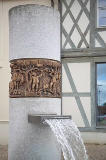 Market fountain with relief on the town's history, water jet, market square, Haldensleben,