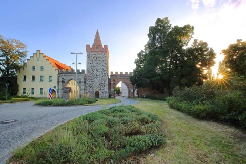 Historic Heath Gate with town wall and building with stepped gable in backlight, town