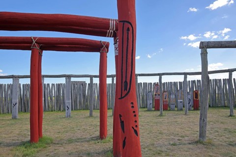 Archaeological reconstructed circular ditch from the Stone Age, Bronze Age, poles with runes, bow