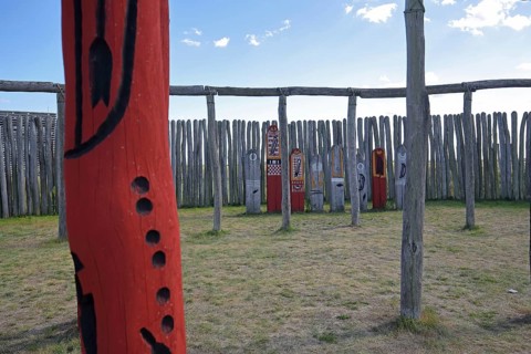 Archaeological reconstructed circular ditch from the Stone Age, Bronze Age, poles with runes, bow