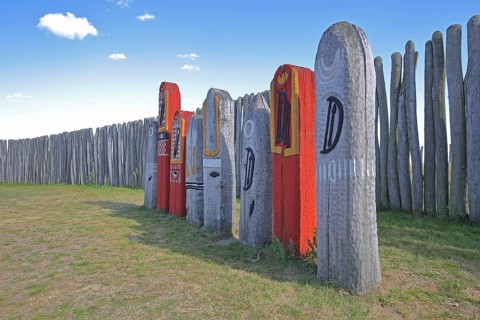 Archaeological reconstructed circular ditch from the Stone Age, Bronze Age, poles with runes, bow