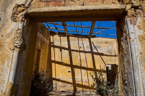 Sunlight casts shadows through dilapidated wooden beams in an old room, Old Silk Factory, German