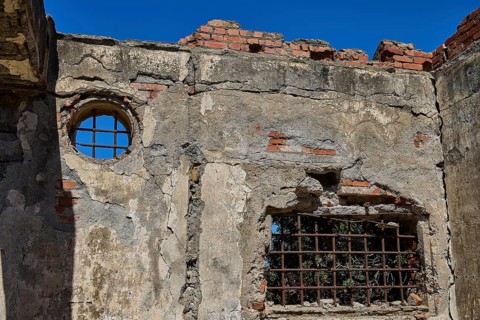 Old walls with round and rectangular lattice window, surrounded by bricks, Old silk factory,
