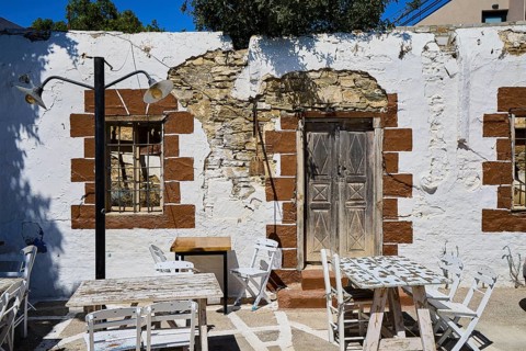 Taverna, Rustic wall with wooden doors, lights and weatherboarded brickwork, Kattavia village,