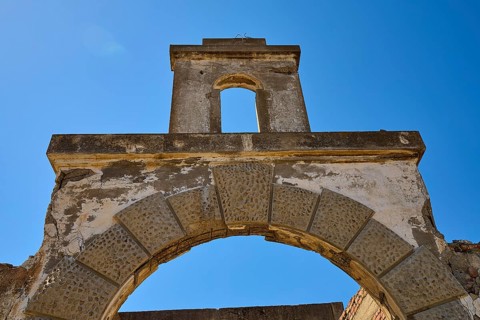Abandoned stone archway under a clear blue sky, showing signs of weathering, Old Silk Factory,
