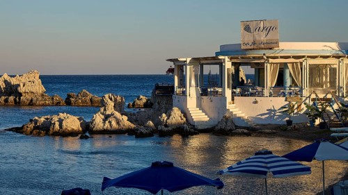 Restaurant Argo, Cosy restaurant by the sea with rocks in the water and evening sun, protected by