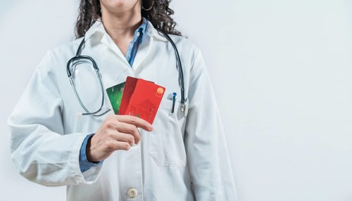 Doctor holding credit cards isolated. Unrecognizable doctor with credit cards, medical payment