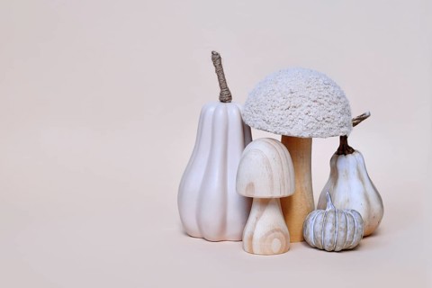 Decorative mushroom and pumpkin ornaments on beige background with copy space. Autumn seasonal