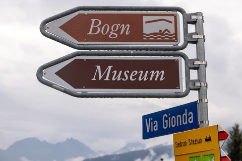 Signpost to the Bogn wellness and adventure pool and museum, Sedrun railway station, Surselva,