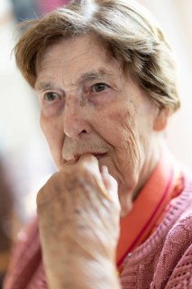 Close-up, authentic, unposed portrait of a 90+ year old senior woman with dementia and Alzheimer's