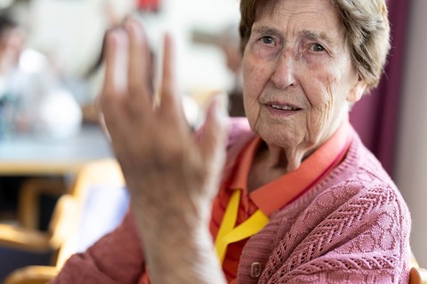 Over 90-year-old senior citizen with dementia talks and gesticulates with her wrinkled hands in a