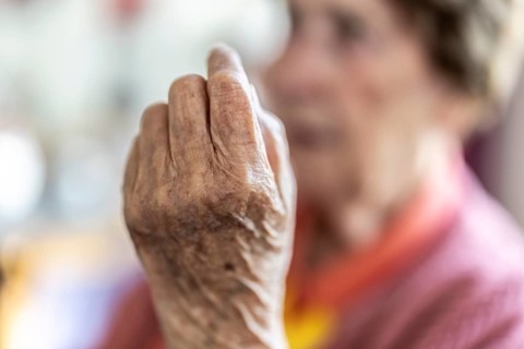 Over 90-year-old senior citizen with dementia talks and gesticulates with her wrinkled hands in a