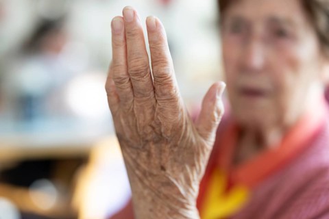 Over 90-year-old senior citizen with dementia talks and gesticulates with her wrinkled hands in a