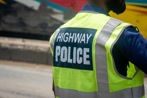 Back view of a highway police officer wearing a reflective vest, Dhaka, Bangladesh