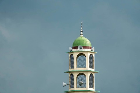 A tower with a dome and speakers against an overcast sky, Dhaka, Bangladesh