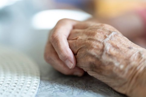 Wrinkled hands of a 90+ year old senior citizen lying on the table in a retirement home, Cologne,