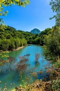 Ibiur reservoir reflecting vibrant trees and a majestic mountain adorned with lush vegetation on a