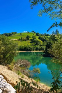 The tranquil waters of ibiur reservoir mirror the vibrant green hills and clear blue sky of the