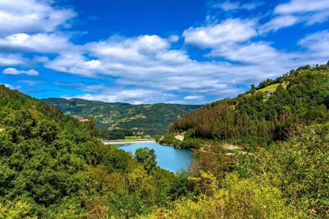 Serene ibiur reservoir nestled among lush hills of tolosa in the basque country, featuring a
