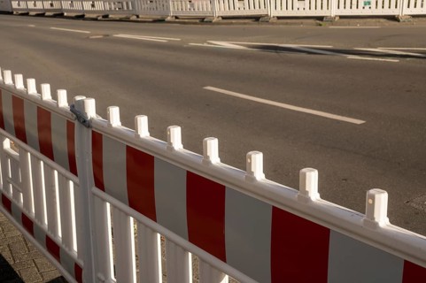 Borken, NRW, Germany, Red and white striped plastic construction barrier closing an empty asphalt