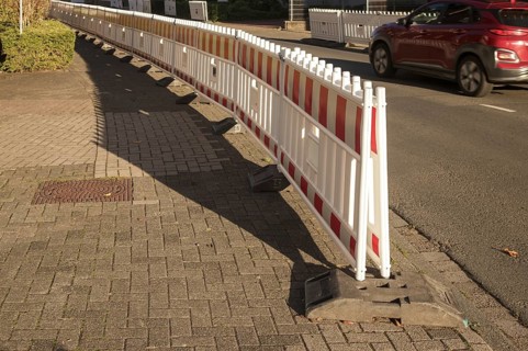 Borken, NRW, Germany, Red and white plastic construction barriers lining a paved walkway beside a