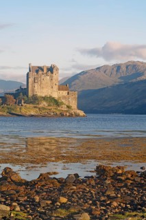Historic castle on an inlet with dramatic mountains in the background, Eilean Donan Castle,