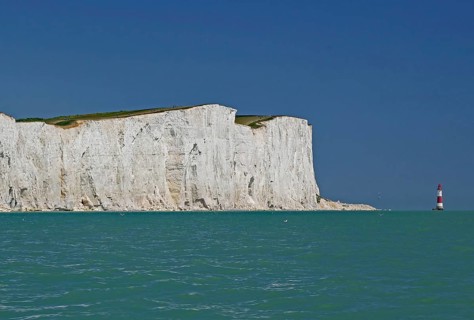 White cliffs on turquoise sea with view of red lighthouse, Old Harrys Rock, Beachy Head Lighthouse,