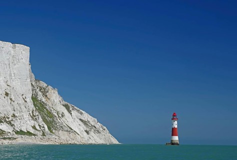 Red lighthouse in front of white cliffs at the blue sea, Old Harrys Rock, Beachy Head Lighthouse,