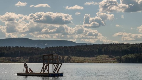Children playing on a platform at a bathing place at Lake Mjøsa or Mjosa with wooded shore,