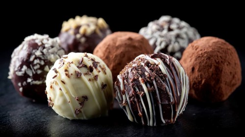 Elegant Dark and White Chocolate Truffles on Black Background. Healthy diet and healthy lifestyle,