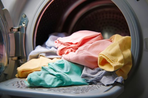 Laundry washing machine, fresh clothes after washing cycle and drying, AI generated