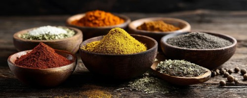 Different spices in bowls on table on rustic dark wooden background. Indian colorful spices for
