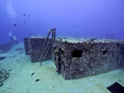 Rusty shipwreck with corals and fish in deep water. Dive site wreck of the USS Spiegel Grove, John