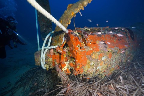 Underwater photo with diver, propeller of an aeroplane and rope in the ocean. Dive site aircraft