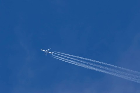 Airbus A340-300 jet aircraft of Lufthansa airlines in flight in a blue sky with vapour trails or