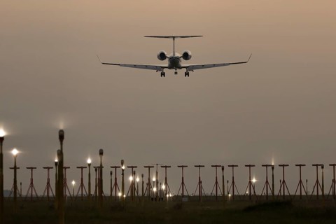 Bombardier Global business jet passenger aircraft in flight landing at sunset at London Stansted