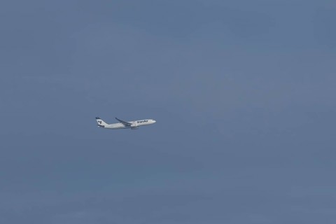 Jet passenger aircraft of Iran Air Airlines flying in a blue sky, England, United Kingdom