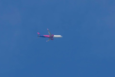 Airbus A321 jet aircraft of Wizz Air airlines in flight in a blue sky, England, United Kingdom