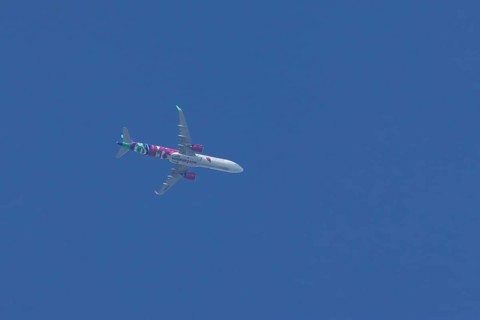 Airbus A321 jet aircraft of Wizz Air airlines in flight in a blue sky, England, United Kingdom