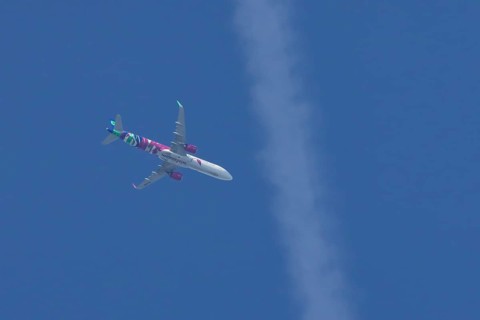 Airbus A321 jet aircraft of Wizz Air airlines in flight in a blue sky, England, United Kingdom