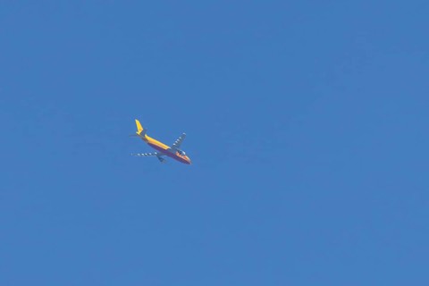 Boeing 767 jet aircraft of DHL cargo airlines in flight in a blue sky, England, United Kingdom