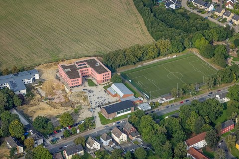 Aerial view, Pink building of the Reinoldi comprehensive school and construction site in the