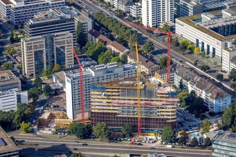 Aerial view, construction site and new construction triangular office tower Eclipse next to the
